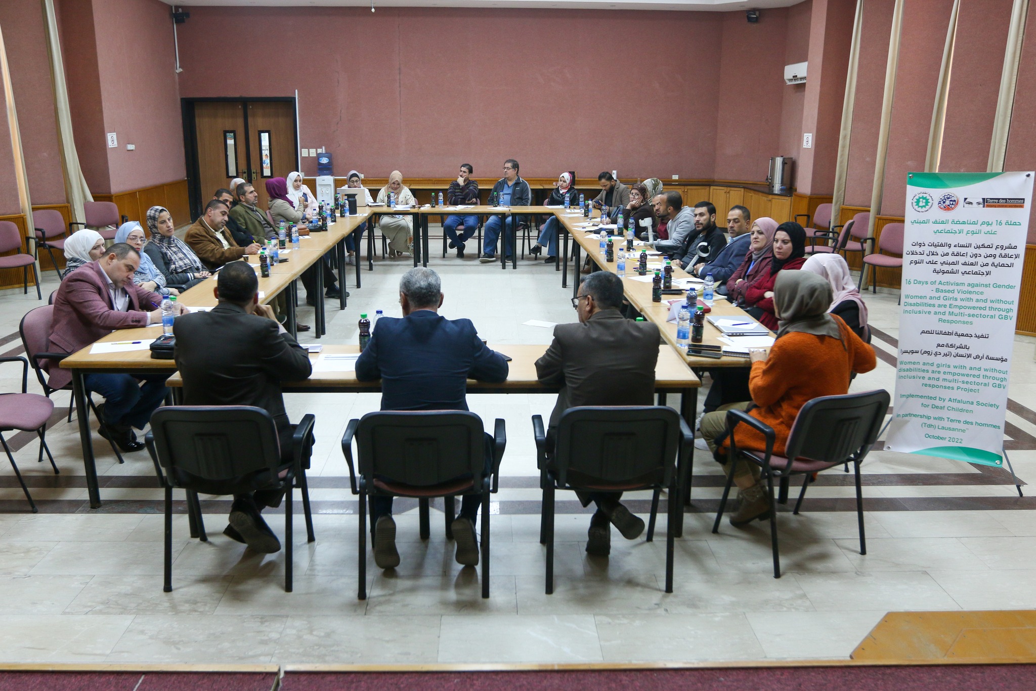 photo of about 40 people sitting in a U shape discussing